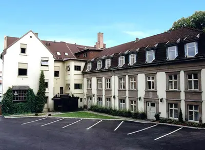 a group of buildings in a parking lot at Grand Hotel Hønefoss in Hønefoss