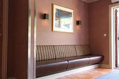 a leather bench in a room with a picture on the wall at Fanitullen Hotel in Hemsedal