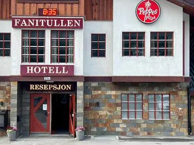 a hotel with a red door and a hotel sign at Fanitullen Hotel in Hemsedal