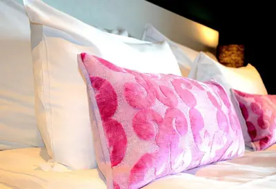 a pink pillow sitting on a bed with white pillows at Thon Hotel Central in Elverum