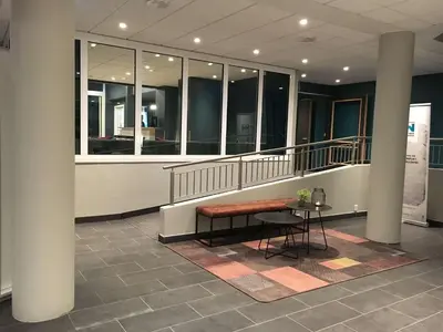 a lobby with a bench and a table in a building at Thon Hotel Central in Elverum