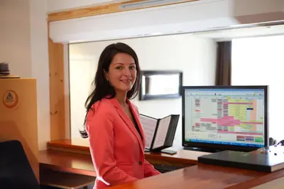 a woman standing in front of a desk with a computer at Kinn Hotell Florø in Florø