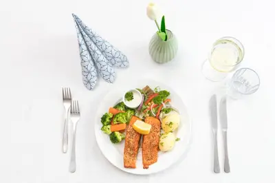 a plate of food with fish and vegetables on a table at Kinn Hotell Florø in Florø