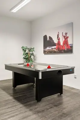 a ping pong table in a room with a painting at Kinn Hotell Florø in Florø