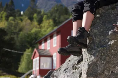 a person is standing on top of a rock at Dragsvik Fjordhotel in Balestrand