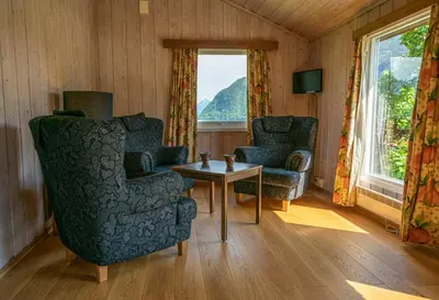a living room with two chairs and a table at Dragsvik Fjordhotel in Balestrand