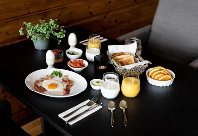 a table with a breakfast of eggs and bread at Dragsvik Fjordhotel in Balestrand