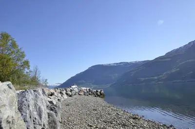 a rock wall next to a body of water at Aga Fjord Apartments Hardanger in Nå