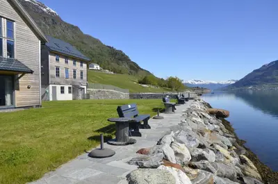 a row of benches sitting next to a body of water at Aga Fjord Apartments Hardanger in Nå