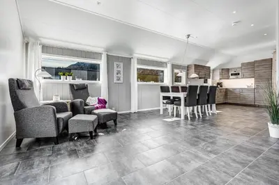 a living room with chairs and a dining room at Aga Fjord Apartments Hardanger in Nå