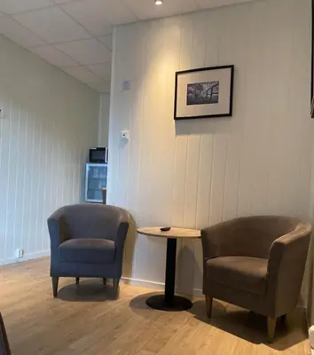 a waiting room with two chairs and a table at Askvoll Fjordhotell in Ask