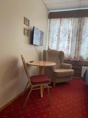 a room with a table and a chair and a couch at Askvoll Fjordhotell in Ask