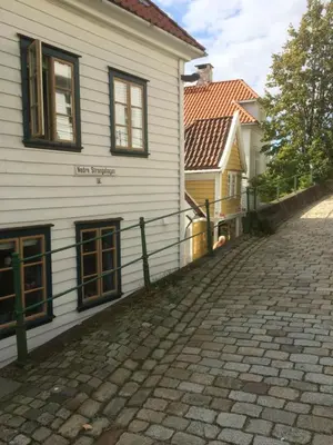 a cobblestone street in front of a white building at Annehelenes B&B in Bergen