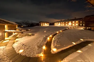 a courtyard covered in snow at night with lights at Bjerkeløkkja Bed and Breakfast in Oppdal