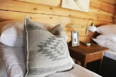 a pillow sitting on a bed next to a table at Bjerkeløkkja Bed and Breakfast in Oppdal