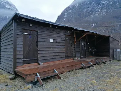 a wooden cabin with two doors on the side of a mountain at Hardanger Basecamp in Osa