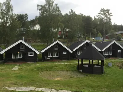 a group of houses with a gazebo in the yard at Fosheim Hytter in Ron