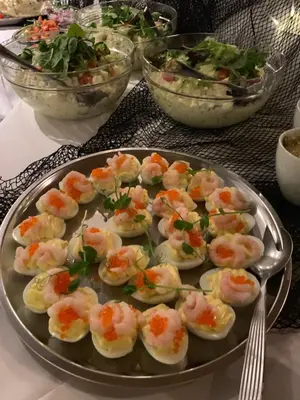 a plate of deviled eggs on a table with bowls of salad at Blix Hotel in Vikøyri
