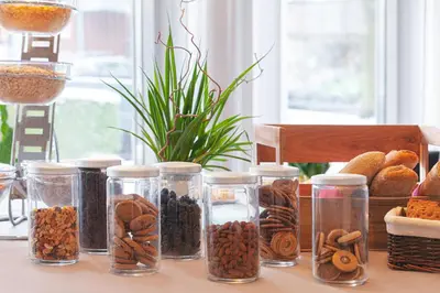 a table with glass jars filled with different types of food at Blix Hotel in Vikøyri