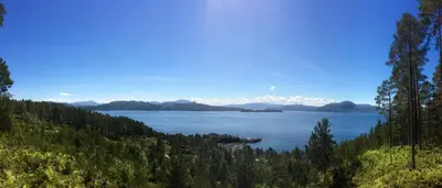 a view of a lake with mountains in the distance at Tustna Ladestasjon in Hals
