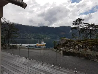 a dock with a boat in a body of water at Ropeid Villa Fjordferie in Ropeid