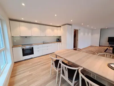 a kitchen and dining room with a table and chairs at Ropeid Villa Fjordferie in Ropeid