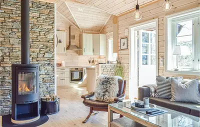 a living room with a stone wall and a fireplace at Tokagjelet in Norheimsund