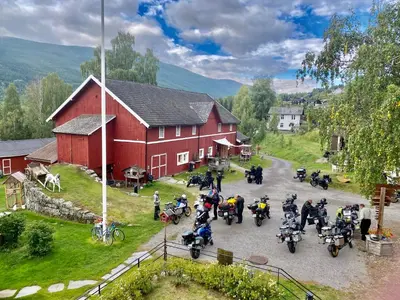 a group of motorcycles parked in front of a red barn at Hesla Farm in Gol