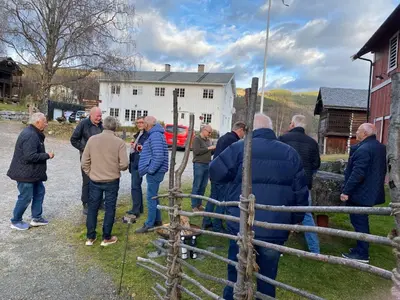 a group of men standing outside of a fence at Hesla Farm in Gol