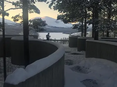 a person standing in the snow with a view of a lake at Rondane Sollia Friluftsliv Øvre Nordli in Sollia