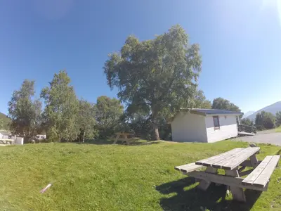 a picnic table in a field next to a building at Volsdalen Camping in Ålesund