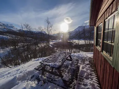 a bench covered in snow next to a building at Maristuen Fjellferie in Borgund