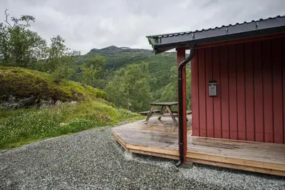 a red cabin with a picnic table on a deck at Maristuen Fjellferie in Borgund