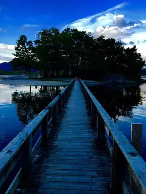 a wooden bridge over a body of water at Skånevik Fjordhotel in Skånevik