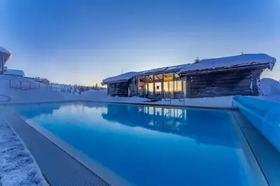 a house in the snow with a swimming pool at Ilsetra Hotell in Hafjell