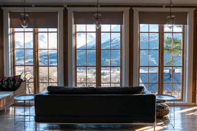 a living room with a couch in front of windows at Klara House in Isfjorden