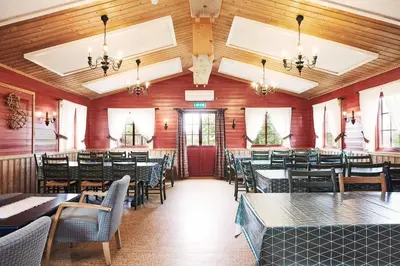 a restaurant with wooden walls and tables and chairs at Brennabu in Ron