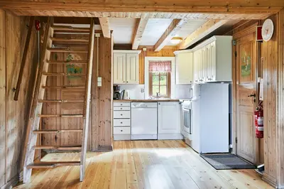 a kitchen with white appliances and a wooden ceiling at Brennabu in Ron