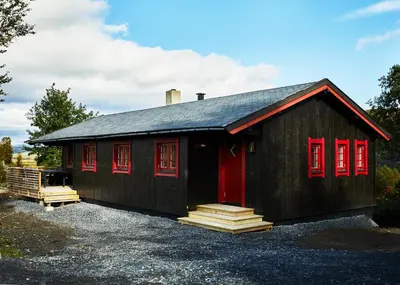 a black house with red doors and red windows at Brennabu in Ron