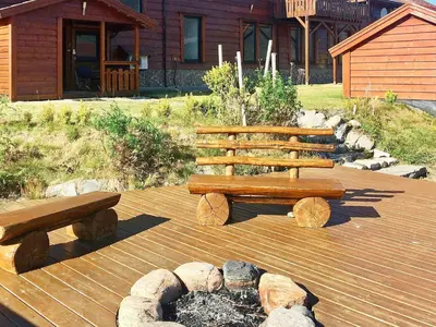 two wooden benches on a deck with a fire place at 10 person holiday home in EIDSVÅG-By Traum in Rød
