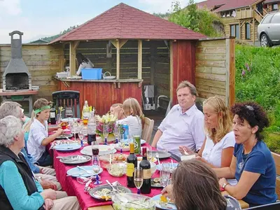 a group of people sitting around a long table at 10 person holiday home in EIDSVÅG-By Traum in Rød