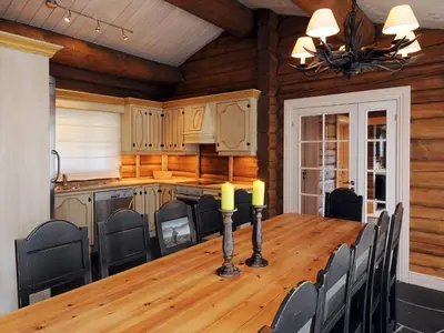 a dining room with a table and a kitchen at 12 person holiday home in Fåvang-By Traum in Favang