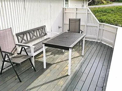 two chairs and a table and a bench on a deck at 4 person holiday home in VEVANG-By Traum in Vevang