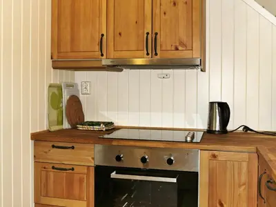 a kitchen with wooden cabinets and a stove top oven at 6 person holiday home in Leirvik i Sogn-By Traum in Bø