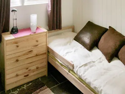 a small bedroom with a bed and a dresser at 6 person holiday home in Leirvik i Sogn-By Traum in Bø