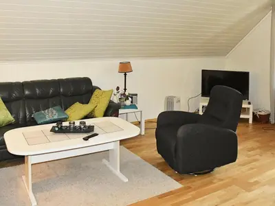 a living room with a couch and a table and a chair at 6 person holiday home in Leirvik i Sogn-By Traum in Bø