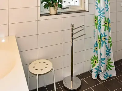 a bathroom with a stool next to a shower at 6 person holiday home in Leirvik i Sogn-By Traum in Bø