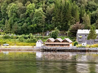 a house on the shore of a body of water at 6 person holiday home in Leirvik i Sogn-By Traum in Bø