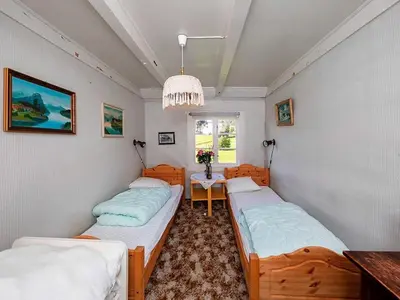 two beds in a room with a table and a window at 8 person holiday home in Liabygda-By Traum in Eidsdal