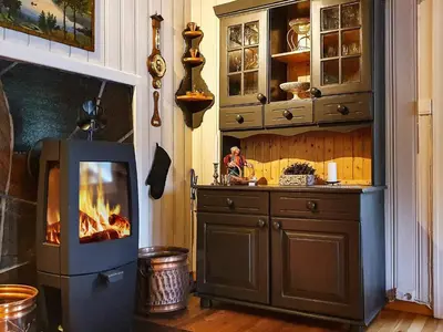 a kitchen with a fireplace and a stove at 8 person holiday home in Sundlandet in Snildal
